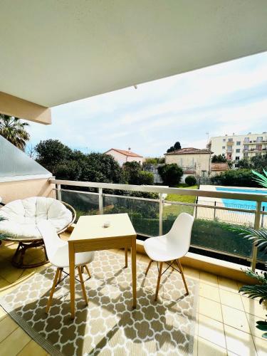 un balcon avec une table et des chaises et une vue dans l'établissement LES PALMIERS - Appartement avec piscine proche plages - Wifi et Clim, à Antibes