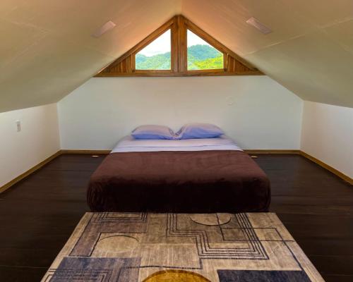 a bedroom with a bed in a attic with a window at El Mangle Suite Front Beach in Ayampe