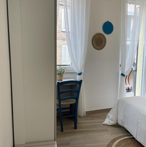 a bedroom with a chair and a bed and a window at Affittacamere Casa Lilibet in San Benedetto del Tronto
