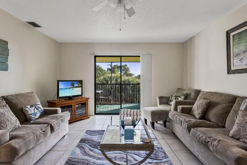 een woonkamer met een bank en een tv bij Beachview Condo #54484 in Holmes Beach