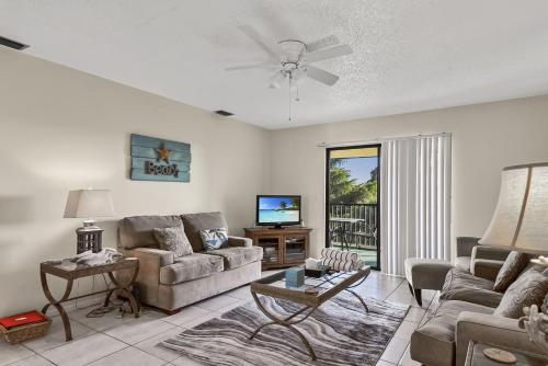 een woonkamer met een bank en een tv bij Beachview Condo #54484 in Holmes Beach