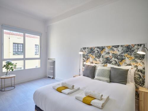 Un dormitorio con una gran cama blanca con dos almohadas. en NEW.Apto-SOL. 3ROOM 3BATHROOM.Recién reformado., en Madrid