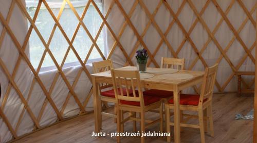 una mesa de madera y sillas en una yurta en Domek i jurta nad rzeką, en Kościerzyna