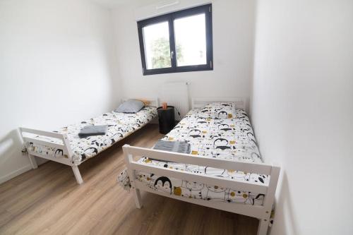 una camera da letto con due letti e una finestra di Villa en bord de mer SPA / Sauna (N) a Bretteville-sur-Ay