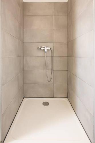 une douche avec pommeau de douche dans une salle de bain dans l'établissement Villa en bord de mer SPA / Sauna (N), à Bretteville-sur-Ay