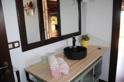ein Bad mit einem Waschtisch, einem Spiegel und einem Waschbecken in der Unterkunft Casa Julia y Chloé in Molvízar