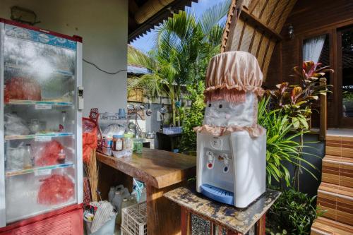 un robot da cucina appoggiato su una sedia accanto a un tavolo di The Catar Cottages a Nusa Penida