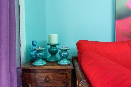 a table with a candle and a red couch at Aegina's Flowers house in Aegina Town