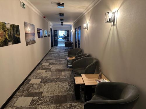 a corridor with chairs and tables in a waiting room at WRZOS resort & wellness in Węgierska Górka