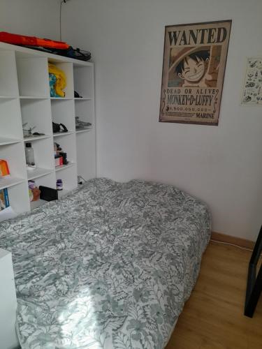 een bed in een kamer met een poster aan de muur bij Le Laurier Rose in Le Pallet