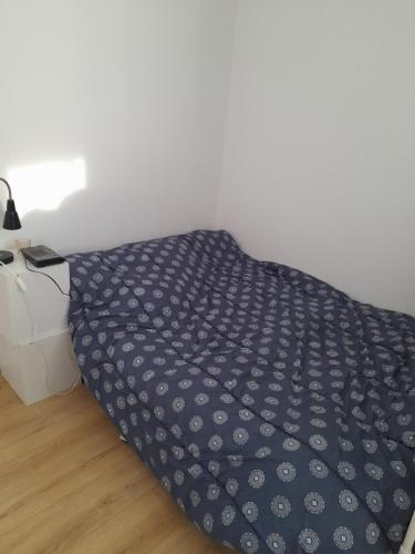 een bed in een kamer met een blauwe sprei bij Le Laurier Rose in Le Pallet
