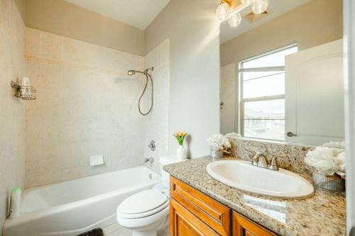 een badkamer met een wastafel, een bad en een toilet bij Sweet Modern House 7mins to Disney in Fullerton