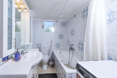 La salle de bains est pourvue d'un lavabo, d'une baignoire et de toilettes. dans l'établissement Aegina's Flowers house, à Égine