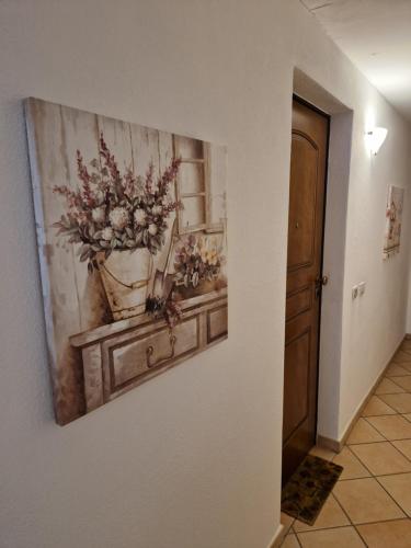 a painting of a vase of flowers on a wall at La Casa di Gió in Centro in Olbia