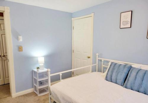 a bedroom with a white bed and a blue wall at The Family Getaway in Tobyhanna