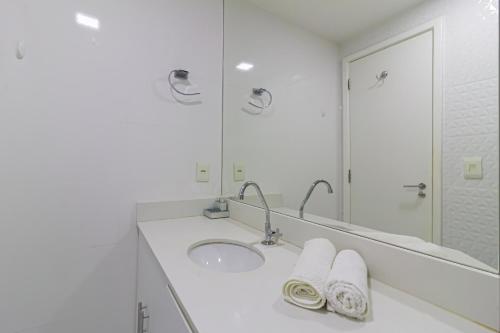 een witte badkamer met een wastafel en een spiegel bij Lobie Ipanema Barão da Torre in Rio de Janeiro