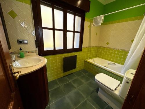 e bagno con lavandino, servizi igienici e vasca. di Casa de Aldea el Pontón a Cue