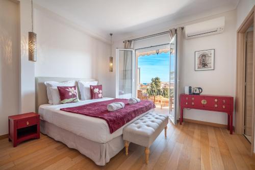 - une chambre avec un grand lit et un balcon dans l'établissement La Fabrique à Poupées - Chambres de charme au coeur de Menton, à Menton