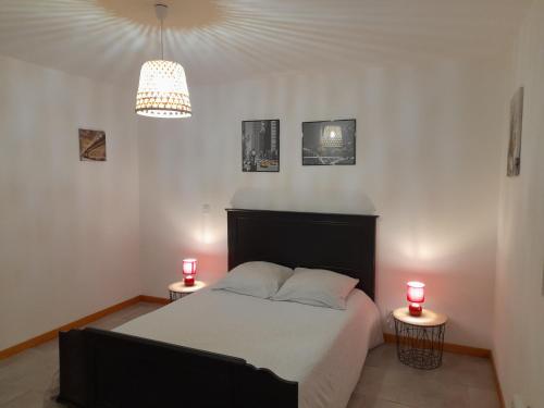 ein Schlafzimmer mit einem Bett und zwei Kerzen auf zwei Tischen in der Unterkunft Les Forges 2 in La Luzerne