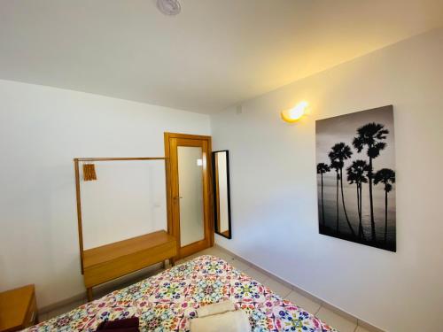 - une chambre avec un lit et une photo de palmiers dans l'établissement Villa Sol, à Ferragudo