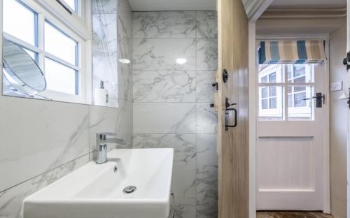 North Creake的住宿－Lovely Cottage，白色的浴室设有水槽和镜子