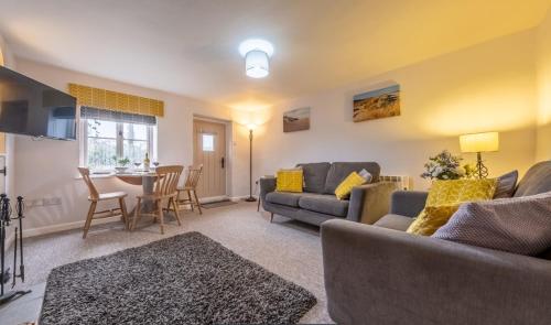 a living room with a couch and a table at Lovely Cottage in North Creake