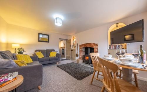 a living room with a couch and a table at Lovely Cottage in North Creake