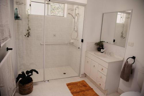 a white bathroom with a shower and a sink at Pandanus Villa - #3 in Yeppoon