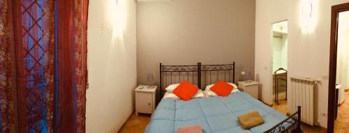 a bedroom with a blue bed with orange pillows at L' Attichetto in Ciampino