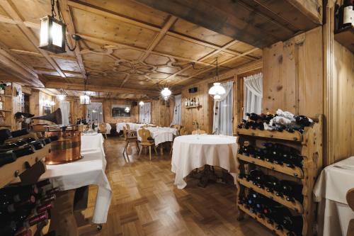 Camana Veglia في ليفينو: مطعم به طاولات وكراسي وزجاجات للنبيذ