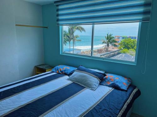 a bedroom with a bed with a view of the ocean at Paradise departamento para vacacionar in Crucita