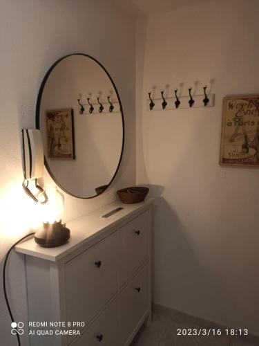 ein Badezimmer mit einem Spiegel und einer Kommode mit einer Lampe in der Unterkunft ATICO AS CORTIÑAS in O Grove