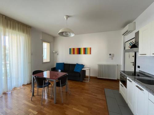 een keuken en een woonkamer met een tafel en een bank bij DEA apartment in Albenga