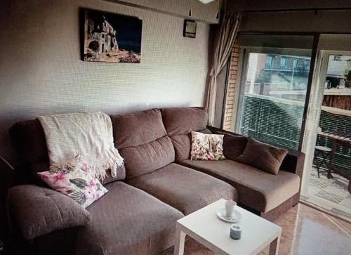 sala de estar con sofá marrón y mesa en Nice apartment on the coast to relax and work en Cartagena