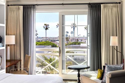 a hotel room with a bed and a large window at Lido House, Autograph Collection in Newport Beach
