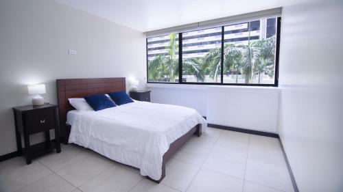 1 dormitorio con cama y ventana grande en Bellini I 2, 2 habitaciones, Puerto Santa Ana, Guayaquil, en Guayaquil