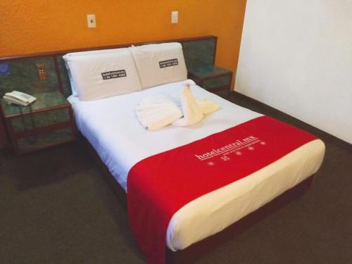 a hotel room with a bed with two towels on it at Hotel Central in Ciudad Nezahualcóyotl