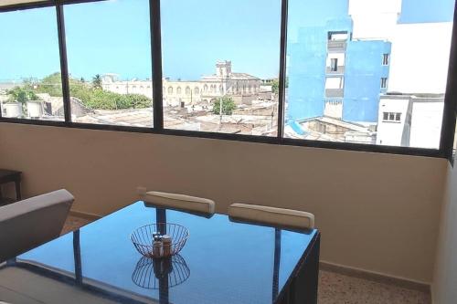 una mesa de cristal en una habitación con vistas a la ciudad en RH02 Riohacha apartamento con vista al mar en la mejor zona de la ciudad genial para relax o trabajo, en Ríohacha