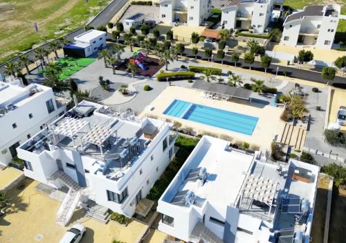 an aerial view of a white house with a swimming pool at NEW Cozy Garden Apartment Pool & Terrace near Sea for up to 6 people in Akanthou