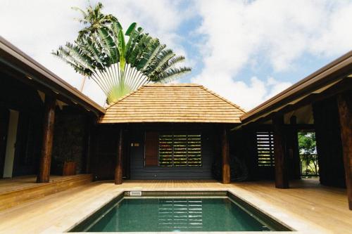 a house with a swimming pool in front of a building at Beachfront Villa - Pod House, Private Plunge Pool in Savusavu