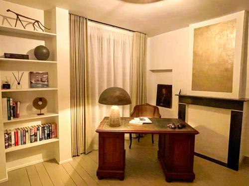 a room with a desk with a lamp on it at La Porte Rouge - The Red Door in Oudenaarde