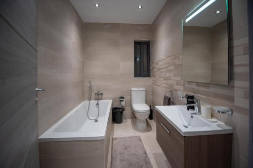 bagno con 2 lavandini, vasca e servizi igienici di Seaside Luxury Apartment a San Pawl il-Baħar