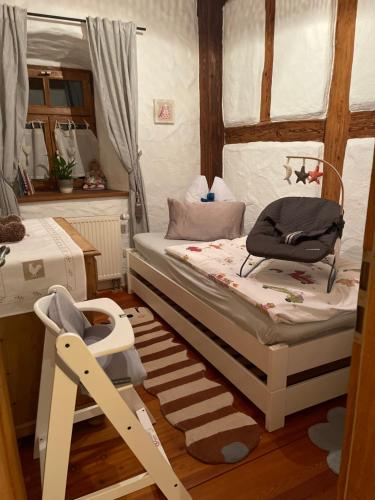 a small bedroom with a bed and a chair at Jurahaus Hirschberg EG Wohnung in Beilngries