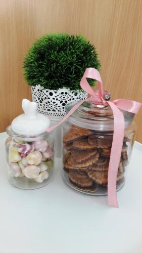 two jars of cookies and a potted plant on a table at Apartments Milena & Ante in Makarska