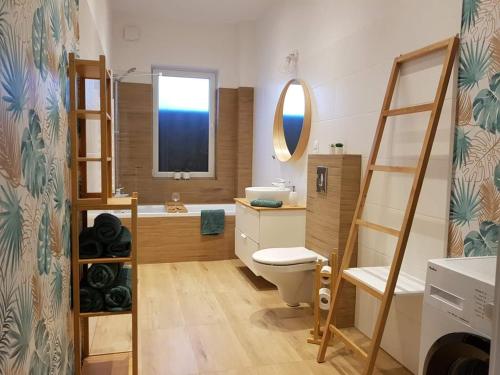 een badkamer met een toilet, een wastafel en een spiegel bij MoryńApartments in Moryń