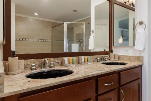 een badkamer met 2 wastafels en een grote spiegel bij Hilton Pool Pass Included - Luxury Living on the Green w Pool Hot Tub & Views in Waikoloa