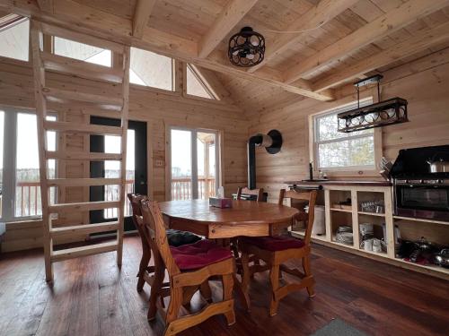 a dining room with a wooden table and chairs at Les Racines du p'tit Isidore in Rouyn