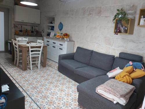a living room with a blue couch and a kitchen at One bedroom apartment in Qormi