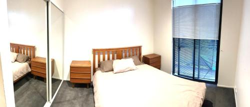 a bedroom with a bed and a mirror at The One Grand Prix Living in Melbourne