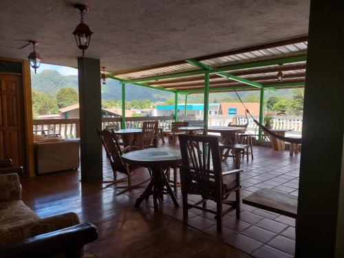 a dining room with tables and chairs and a balcony at Residencial El Valle in Valle de Anton